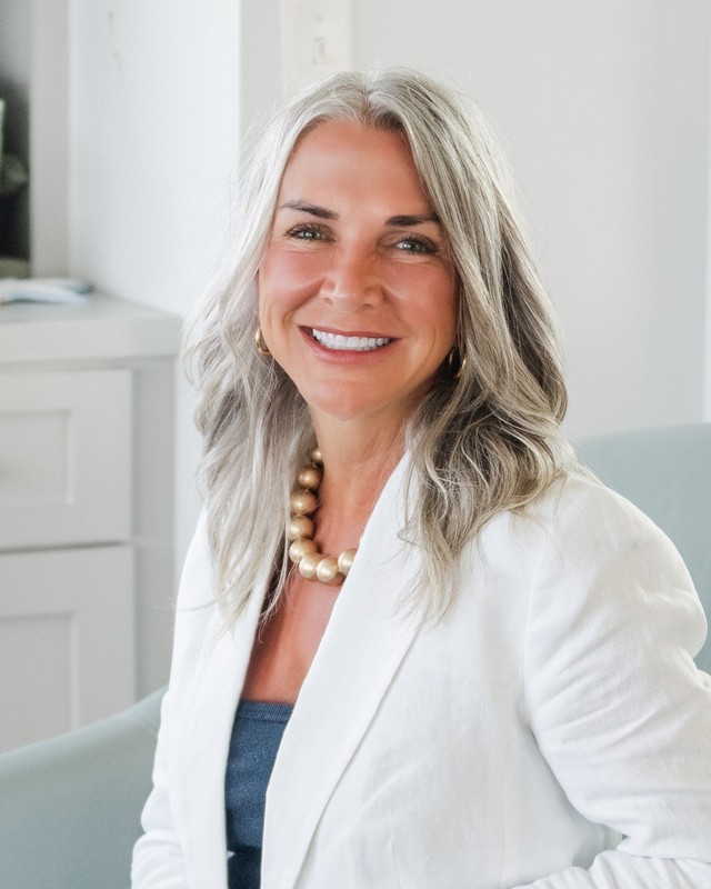Portrait of Dr. Jude Black, Co Founder of WON VET™, in a white suit in a bright living room